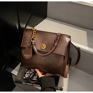 Detail of vintage coffee PU leather backpack with gold clock buckle and chain decoration