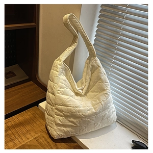 Close-up of white quilted tote bag with bubble fabric texture on a sunny windowsill