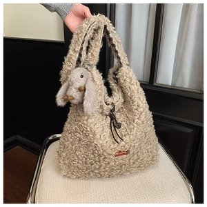 Macro detail of plush cream tote bag featuring fluffy material and a cute rabbit charm