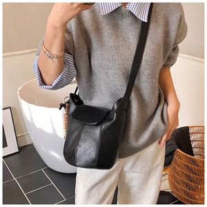 Detailansicht einer schwarzen matten Eimertasche aus Leder mit Klappe und Nähten
