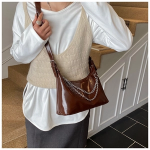 Détail du sac sous le bras en cuir PU marron brillant avec doubles chaînes argentées