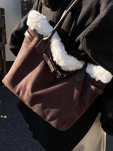 Retro brown suede tote bag with white faux fur trim and silver buckle shown on shoulder