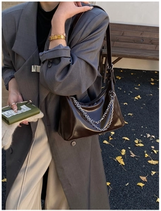 Vue détaillée du sac à bandoulière marron glacé avec chaîne et veste de blazer grise