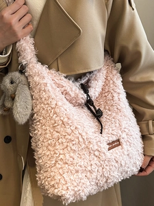 Pink faux shearling tote bag with a rabbit charm and leather logo patch detail