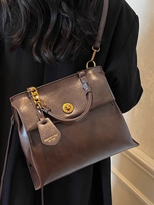 Vintage brown PU leather backpack with gold clasp and chain strap shown on a female model