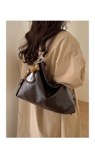 Détail du sac cabas en cuir marron avec miroir coeur et breloque léopard sur modèle