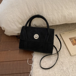 Close-up of black matte texture bag with silver metal rotating lock and dual handles