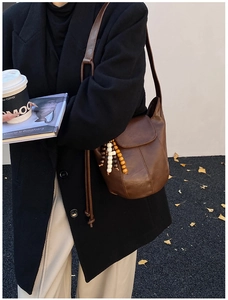 Detailansicht braune Vintage-Beuteltasche mit bunten Holzperlen-Quasten-Verzierung