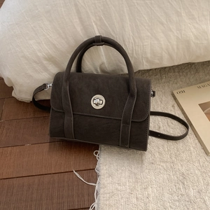 Detail of vintage coffee brown crossbody bag with matte finish and silver twist lock