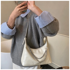 Détail du sac hobo crème souple avec une élégante double chaîne en métal argenté
