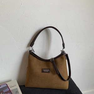 Detail of the vintage brown suede semi-moon shoulder bag with leather strap and silver metal