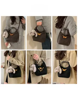 Dettaglio di borse a secchiello vintage in nero e marrone con ciondoli in peluche