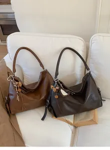 Détail de sacs hobo vintage en marron et café foncé avec miroir léopard et breloques en peluche