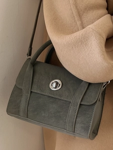 Vintage olive green faux leather crossbody bag with silver twist lock on camel coat