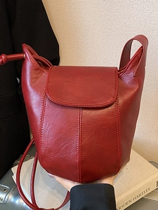 Minimalistische weinrote Bucket Bag aus Leder mit mattem Finish und Schultergurt