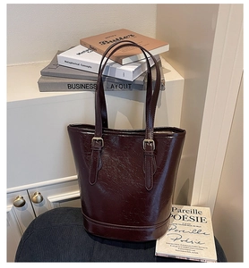Close-up of deep burgundy oil wax leather tote bag with elegant metal buckle details