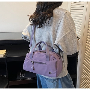 Detail of light purple nylon tote with silver hardware and shoulder strap on model