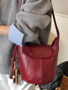 Minimalistische weinrote Beuteltasche aus Kunstleder mit Perlenquaste und Ziernähten