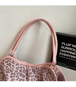 Detail of pink leopard print canvas tote with pink leather strap and metal ring attachment