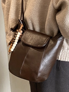 Minimalistische dunkelbraune matte Eimertasche mit Vintage-Perlenanhänger und Klappe