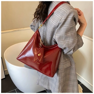 Detail of dark red faux leather Hobo tote bag with mini purse and thin shoulder strap