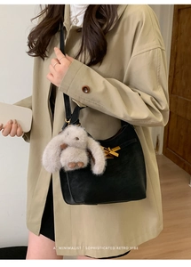 Borsa a tracolla nera minimalista in pelle con chiusura dorata e ciondolo a coniglio