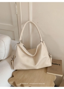 Détail du sac cabas en similicuir crème montrant la bandoulière large et le zip en métal