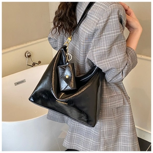 Detail of black faux leather tote with detachable coin purse and gold hardware accents