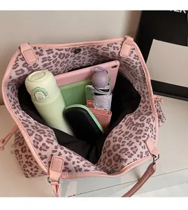Spacious interior of leopard print tote bag holding a tablet, umbrella, and essentials