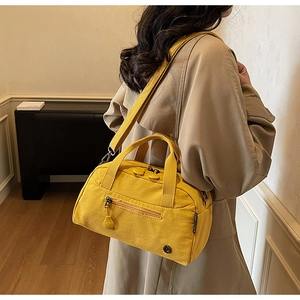 Detail of ginger yellow canvas Boston bag with adjustable shoulder strap for women