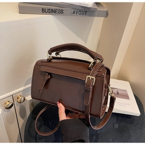 Gros plan d'un sac bandoulière vintage en cuir marron foncé dans un cadre chic intérieur
