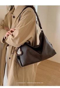 Détail du sac vintage marron avec charm miroir cœur léopard et texture mate élégante