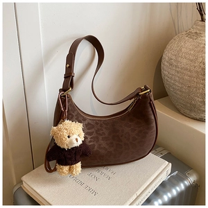 Detail view of the brown leopard print hobo bag with a cute bear plush keychain accessory
