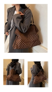 Detail of suede tote bag featuring pink polka dot patterns and leather shoulder strap