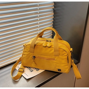 Detail shot of yellow nylon bag showing smooth metal zipper and wide fabric handles