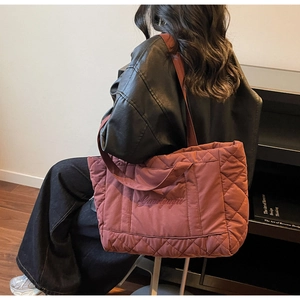 Quilted tote bag in dark red nylon with large capacity shown in a daily carrying scene