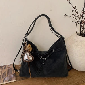 Détail du grand sac cabas en cuir mat noir avec boucles et charme de coeur léopard