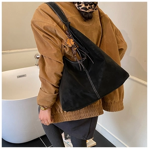 Détail du grand sac cabas noir mat avec coutures blanches et breloque trèfle