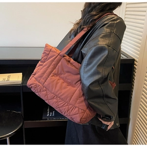 Quilted tote bag in dark rose satin with embroidery shown on model for size perspective