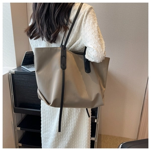 Détail du grand sac cabas kaki avec anses noires dans un cadre de bureau moderne