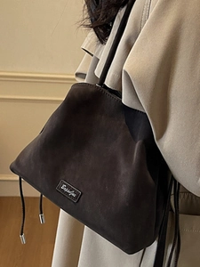 Modern dark brown suede bucket bag for women featuring a stylish drawstring design
