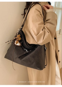 Détail du sac cabas en cuir mat gris foncé avec cœur léopard et breloque en pompon