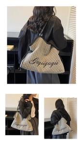 Close-up of grey star print tote bag with black leather straps and cursive text