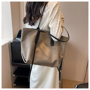Détail d'un grand sac cabas kaki avec des bretelles noires et une texture en nylon robuste