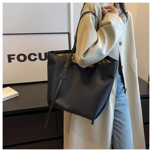 Vue détaillée du grand sac cabas noir porté par un mannequin pour un style de bureau