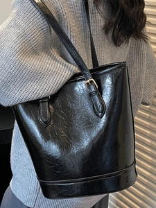 Retro black faux leather tote bag with vintage texture shown on female shoulder