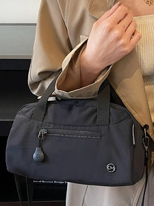 Minimalist black nylon crossbody tote bag with adjustable strap and front zipper pocket