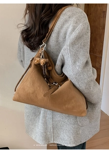 Détail du grand sac cabas rétro marron avec pompon léopard et boucles latérales ajustables