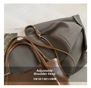 Detail view of adjustable strap with silver buckle on dark brown leather bucket bag