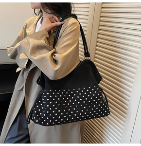 Detail of a large capacity tote bag featuring polka dot pattern and stylish embroidery